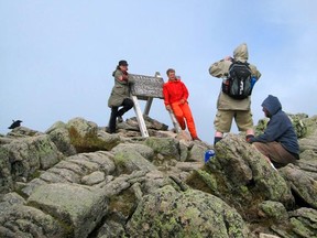 FILE - This Aug. 27, 2014, file photo, shows hikers posing for triumphant photos atop Mount Katahdin in Baxter State Park in Maine. Katahdin is the northern terminus of the Appalachian Trail. As a summer vacation destination, Maine has something for everyone, from hiking and beaches to adventure and the arts. (AP Photo/Beth J. Harpaz, File)