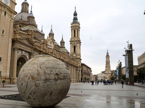 This March 27, 2017 photo shows a view of the Plaza del Pilar in Zaragoza, Spain. A global sculpture is in the foreground, the Basilica del Pilar is to the left and at the far end of the square is the Cathedral of the Savior of Zaragoza, known as La Seo. (Michelle Locke via AP)