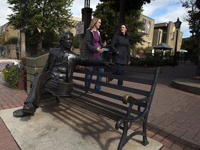 Pedestrians pass a bronze sculpture of Sir John A. Macdonald, Canada's first prime minister in Charlottetown