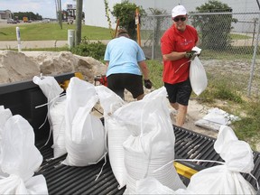 Bill and Leslie O'Brien of Vancleave, Miss., fill sandbags on Monday, June 19, 2017, at the Harrison County Road Department in Gulfport, Miss., for a friend in preparation for expected heavy rains later this week from a tropical system developing in the Gulf of Mexico. (John Fitzhugh/The Sun Herald via AP)