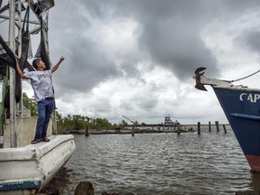 Fisherman Thiet Tran said he was coming in early from Lake Borgne because of the bad weather. He looks up at the clouds while docked in Bayou Bienvenue as Tropical Storm Cindy heads toward Louisiana on Tuesday, June 20, 2017. (Chris Granger/NOLA.com The Times-Picayune via AP)