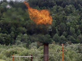 FILE - In this June 15, 2005 file photo, flames from methane burning at the landfill in Coventry, Vt. The Trump administration is delaying two Obama-era regulations aimed at restricting harmful methane emissions from oil and gas production.  (AP Photo/Toby Talbot, File)