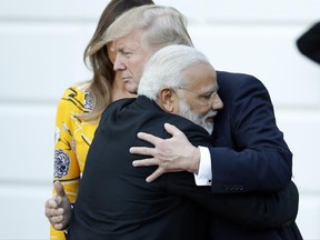 FILE - In this June 26, 2017, file photo, Indian Prime Minister Narendra Modi hugs President Donald Trump as Modi departs the White House in Washington. U.S. President Donald Trump should have been ready for a bear hug from Narendra Modi this week in Washington. The folksy embrace has become a signature move for the Indian prime minister in greeting global leaders and celebrities alike. (AP Photo/Alex Brandon, File)