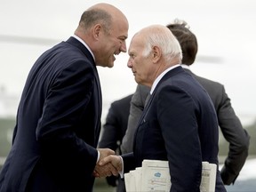 In this June 7, 2017, photo, National Economic Council chairman Gary Cohn, left, shakes hands with real estate developer Steve Roth, right, as they arrive at Andrews Air Force Base, Md., to board Marine One for a short trip back to the White House after Trump spoke about healthcare and infrastructure in Cincinnati. The White House plans to privately negotiate a massive overhaul of the tax system with Republican leaders in Congress, possibly giving rank-and-file members little if any say over the finished product, a top aide to President Donald Trump said June 20. Cohn said the administration doesn't want to engage in prolonged negotiations after the package is made public this fall. Cohn said the goal is to release the overhaul in the first two weeks of September. (AP Photo/Andrew Harnik)