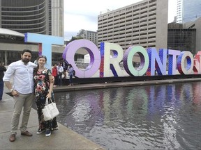 In this June 26, 2017 photo, Khaled Almilaji poses with his wife, Jehan, in Toronto. Dr. Almilaji, who coordinated a campaign that vaccinated 1.4 million Syrian children and risked his life to provide medical care during the country's civil war, says he won't return to the United States to finish his studies at Brown University because of the Trump administration's travel ban. He was recently awarded a medal for meritorious service from Queen Elizabeth II.(Courtesy of Khaled Almilaji via AP)
