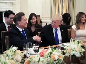 President Donald Trump with first lady Melania Trump, right, shakes hand with South Korean President Moon Jae-in, left, during a dinner in the State Dining Room of the White House in Washington, Thursday, June 29, 2017. (AP Photo/Manuel Balce Ceneta)