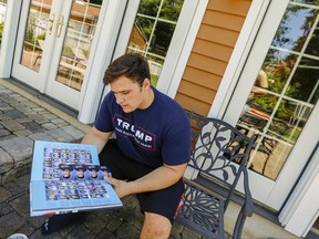 In this June 9, 2017 photo, Grant Berardo, a junior at Wall High School, flips through the 2017 Wall High School yearbook in Wall, N.J., which includes a photo of him wearing a digitally altered T-shirt which originally included the words "Trump Make America Great Again." Superintendent Cheryl Dyer said Berardo's Trump T-shirt was digitally painted a nondescript black even though the shirt did not violate the school's dress code. Two other students previously reported their entries in the yearbook were also altered to remove references to Trump. The school board on Tuesday, June 20 voted to formalize the suspension of the digital media teacher who was the yearbook adviser, while President Trump praised the students. (Andrew Mills/NJ Advance Media via AP)