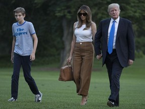 President Donald Trump, first lady Melania Trump, and their son and Barron Trump walk from Marine One across the South Lawn to the White House in Washington, Sunday, June 11, 2017, as they return from Bedminster, N.J.