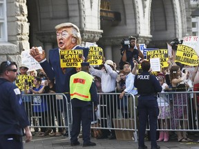 Protesters gather outside the Trump International Hotel in Washington, Wednesday, June 28, 2017, as President Donald Trump arrives at the hotel for fundraiser. (AP Photo/Manuel Balce Ceneta)