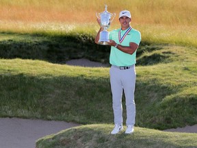 Brooks Koepka poses with the winner's trophy after his victory at the 2017 U.S. Open at Erin Hills on June 18, 2017.