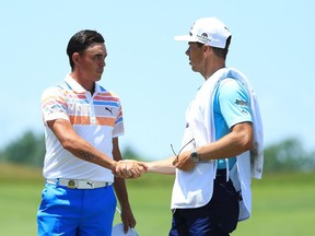 Rickie Fowler (left) shakes hands with his caddy, Joe Skovron, on the ninth green of the U.S. Open on June 15.