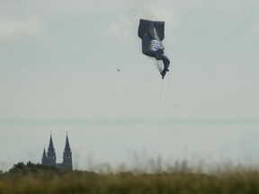 FILE - In this June 15, 2017 file photo, a blimp crashes during the first round of the U.S. Open golf tournament near Erin Hills in Erin, Wis. A preliminary report released by the National Transportation Safety Board on Monday, June, 26, 2017 says tears in the fabric of a hot-air blimp caused it to crash near the U.S. Open. The NTSB says the airship was returning to the Erin airport on because the winds were too strong. The pilot was approaching the airstrip at an altitude of about 200 feet when he encountered a thermal updraft, which sent the airship up to 500 feet. (AP Photo/Charlie Riedel File)