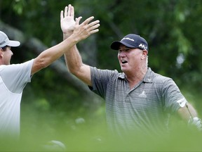 Duffy Waldorf, right, celebrates with Billy Andrade after hitting a hole-in-one on the third hole during the first round of the U.S. Senior Open golf tournament, Thursday, June 29, 2017, in Peabody, Mass. (AP Photo/Michael Dwyer)