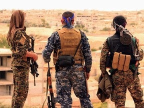 A file photo of soldiers from the Syrian Democratic Forces (SDF)  looking toward the northern town of Tabqa, Syria