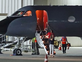 A crying woman exits a transport plane carrying Otto Warmbier, a 22-year-old University of Virginia undergraduate student who was imprisoned in North Korea in March 2016, as he is transferred  to an ambulance at Lunken regional airport, Tuesday, June 13, 2017, in Cincinnati.