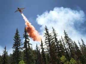 A plane drops fire retardant as a wildfire burns along State Route 143, Sunday, June 18, 2017, the primary road to the southern Utah ski town of Brian Head, Utah. Firefighters were hoping to have a blaze near a southwestern Utah ski town 10 percent contained by Sunday. Some 750 residents and visitors have been evacuated. No injuries have been reported. (Leah Hogsten /The Salt Lake Tribune via AP)/The Salt Lake Tribune via AP)
