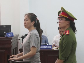 Prominent blogger Nguyen Ngoc Nhu Quynh, left, stands trial in the south central province of Khanh Hoa, Vietnam, Thursday, June 29, 2017. She was accused of distorting government policies and defaming the Communist regime on her Facebook posts, her lawyer said. Quynh, also known as "Mother Mushroom," denied the charges against her during her trial, lawyer Le Van Luan said. He said the prosecutors requested 8-to-10 years in prison. (Vietnam News Agency via AP)