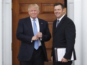 FILE - In this Nov. 20, 2016, file photo, Kansas Secretary of State Kris Kobach, right, holds a stack of papers as he meets with then President-elect Donald Trump at the Trump National Golf Club Bedminster clubhouse in Bedminster, N.J. Civil rights advocates say Kobach is trying to hide materials that undercut his public claim that substantial numbers of noncitizens have registered to vote. The American Civil Liberties Union obtained the documents as part of its federal civil lawsuit in Kansas challenging the state's proof-of-citizenship document requirement. It wants to court to remove the confidential designation Kobach placed on materials he was photographed taking into a November meeting. (AP Photo/Carolyn Kaster, File)