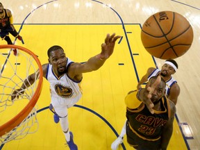 Kevin Durant, left, of the Golden State Warriors tries to defense LeBron James of the Cleveland 
Cavaliers during Game 1 of the NBA Finals Thursday night in Oakland. Durant had 38 points as the Warriors drew first blood with a 113-90 victory.
