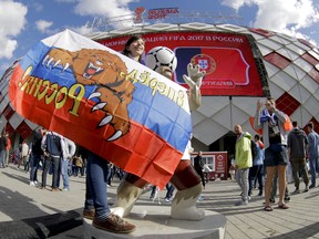A Russian supporter poses for pictures outside the stadium, prior to the Confederations Cup, Group A soccer match between Russia and Portugal, at the Spartak Stadium in Moscow.