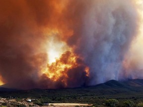 In this Tuesday, June 27, 2017 frame from video, flames and smoke rise from a fire near Mayer, Ariz. The Arizona fire forced the evacuation of Mayer along with several other mountain communities in the area. (Jennifer Johnson via AP)