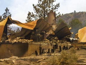 This Saturday, June 24, 2017, photo, shows a cabin burnt to the ground by a wildfire fire on the west side of Panguitch Lake, near Panguitch, Utah. Nearly 1,000 firefighters battled a Utah wildfire that grew Sunday morning that has prompted the evacuation of over a 1,000 people from hundreds of homes and cabins. (Jordan Allred/The Spectrum via AP)