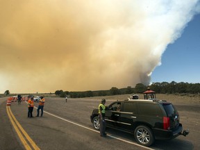 Officers stop cars heading in Panguitch, Utah, heading to Panguitch Lake on highway 143 as the fire approaches, Thursday, June 22, 2017.  (Rick Egan/The Salt Lake Tribune via AP)