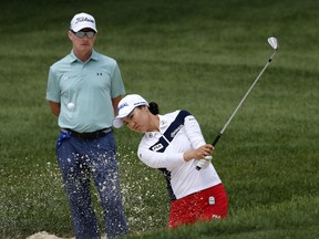 So Yeon Ryu of South Korea hits out of a bunker as coach Cameron McCormick watches during a practice round of the 2017 Women's PGA Championship golf tournament at the Olympia Fields Country Club Wednesday, June 28, 2017, in Olympia Fields, Ill. (AP Photo/Charles Rex Arbogast)