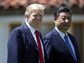 President Donald Trump and Chinese President Xi Jinping walk together after their meetings at Mar-a-Lago in Palm Beach, Fla.