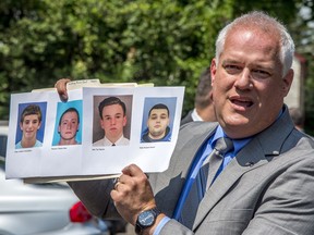 Bucks County District Attorney Matthew Weintraub holds up photos of four men who are missing during a news conference in Solebury Township, Pa., Monday, July 10, 2017.