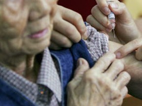 An elderly person receives a flu vaccination on November 7, 2005