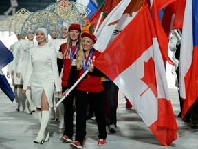 In this Feb. 23, 2014 file photo, Canadian flag bearers Kaillie Humphries (right) and Heather Moyse march in the closing ceremonies of the Sochi Olympics.