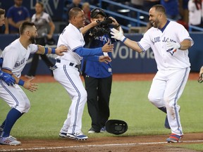 Kendrys Morales is congratulated by Blue Jays teammate Ezequiel Carrera after hitting a game-winning solo home run in the ninth inning against the Oakland Athletics at Rogers Centre in Toronto on Wednesday night.
