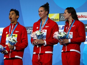 Javier Acevedo, Chantal van Landeghem and Penny Oleksiak stand on the podium after receiving their bronze medals form the mixed 4x100m freestyle replay on Day 16 of the 2017 world aquatics championships on Saturday, July 29, 2017 in Budapest, Hungary.