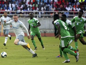 Everton striker Wayne Rooney, right, runs with the ball past Gor Mahia's defenders during their friendly soccer match at Dar es Salaam national stadium in Tanzania, Thursday, July 13, 2017. (AP Photo/Khalfan Said)