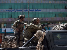 Afghan security forces look on near the site of an ongoing attack on the Iraqi embassy in Kabul on July 31, 2017
