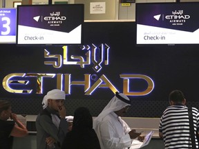 Passengers check into a flight at Abu Dhabi International Airport in Abu Dhabi, United Arab Emirates, Tuesday, July 4, 2017. Abu Dhabi's airport is the first among Mideast airports targeted by a U.S. ban on laptops in airplane cabins to be exempt from the list. (AP Photo/Jon Gambrell)