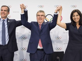 From left, Mayor of Los Angeles Eric Garcetti, International Olympic Committee, IOC, President Thomas Bach, and Mayor of Paris Anne Hidalgo gesture, during a press conference after the International Olympic Committee (IOC) Extraordinary Session, at the SwissTech Convention Centre, in Lausanne, Switzerland, Tuesday, July 11, 2017. ﻿If they can agree who goes first, Paris and Los Angeles will be awarded the 2024 and 2028 Olympics. ﻿International Olympic Committee members voted unanimously to seek a consensus three-way deal between the two bid cities and the IOC executive board. Talks will open with Paris widely seen as the favorite for 2024. (Jean-Christophe Bott,Keystone via AP)