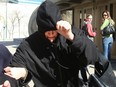 Andrea Giesbrecht tries to hide from the media as she leaves the Law Courts in Winnipeg, Man. Thursday April 21, 2016.