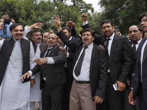 Lawyers shout "go Nawaz go" after leaving the Supreme Court following proceedings on corruption allegations case against Prime Minister Nawaz Sharif's family, in Islamabad, Pakistan, Monday, July 17, 2017. The lawyers for opposition parties requested the court disqualify the country's Prime Minister Nawaz Sharif as he did not deserve to remain in power after a probe found that the premier and his family possessed wealth beyond their known sources of income. The court is expected to rule on the petitions in the coming weeks. (AP Photo/Anjum Naveed)