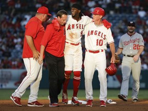 Los Angeles Angels' Cameron Maybin, center, is helped off the field after being injured sliding into second during the first inning of the team's baseball game against the Washington Nationals in Anaheim, Calif., Tuesday, July 18, 2017. (AP Photo/Chris Carlson)