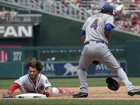 Washington Nationals' Bryce Harper, left, slides into third during the fifth inning of a baseball game against New York Mets third baseman Wilmer Flores (4), Tuesday, July 4, 2017, in Washington. Harper hit a single and went to third on a fielding error by the Mets' Jay Bruce. (AP Photo/Nick Wass)