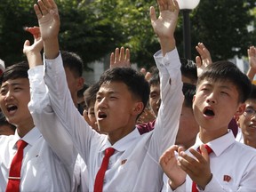 People react as they watch the news that North Korean leader Kim Jong Un signed the order to carry out the test-fire of intercontinental ballistic rocket near the Pyongyang railway station in Pyongyang, North Korea, Tuesday, July 4, 2017. North Korea claimed to have tested its first intercontinental ballistic missile in a launch Tuesday, a potential game-changing development in its push to militarily challenge Washington -- but a declaration that conflicts with earlier South Korean and U.S. assessments that it had an intermediate range. (AP Photo/Jon Chol Jin)