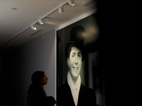 A woman watches a picture of Carlos Gardel at his museum in Buenos Aires, Argentina, Wednesday, July 5, 2017. A museum paying homage to Argentina's greatest tango singer is reopening at his home in Buenos Aires. Gardel set the standard for Latin American leading men in films during the 1920's and 1930s and gave tango a huge boost worldwide. The legacy of the Frank Sinatra-like crooner remains alive in the decades since his death in a 1935 air crash in Colombia. (AP Photo/Natacha Pisarenko)