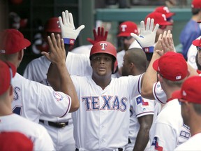 Texas Rangers' Hanser Alberto is congratulated in the dugout after scoring on a Rougned Odor single in the fourth inning of a baseball game against the Baltimore Orioles on Sunday, July 30, 2017, in Arlington, Texas. (AP Photo/Tony Gutierrez)