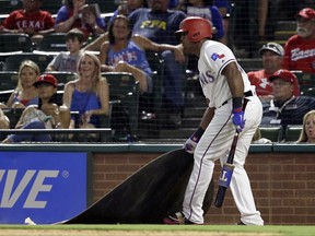 Texas Rangers' Adrian Beltre drags the on deck circle toward himself after being told by tje home plate umpire to get back to the circle during a Nomar Mazara at-bat in the eighth inning of a baseball game against the Miami Marlins on Wednesday, July 26, 2017, in Arlington, Texas. Crew chief Gerry Davis ejected Beltre after that action in the 22-10 Mariners' win. (AP Photo/Tony Gutierrez)