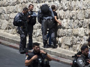 Israeli police officers detain a Palestinian youth outside the Lion's Gate near the Al Aqsa Mosque compound in Jerusalem's Old City, Sunday, July 23, 2017.
