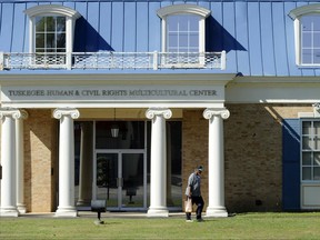 In this Tuesday, April 4, 2017 photo, an unidentified man walks past the Tuskegee Human and Civil Rights Multicultural Center in Tuskegee, Ala. The Trump administration is opposing a bid to use unclaimed money from a legal settlement to fund the museum, which includes exhibits honoring victims of the government's infamous Tuskegee syphilis study. (AP Photo/Jay Reeves, File)