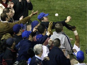 In this Oct. 14, 2003 file photo, Chicago Cubs fan Steve Bartman (top centre) deflects a foul ball during a playoff game at Wrigley Field.