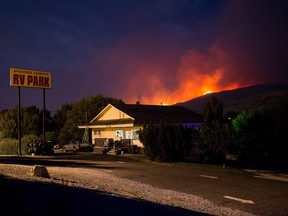 A wildfire burns on a mountain behind an RV park office in Cache Creek, B.C., in the early morning hours of Saturday July 8, 2017.